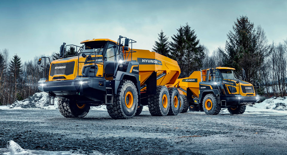 HD Hyundai HA45A & HA30A Knickgelenk-Dumper auf einer verschneiten Baustelle mit Bäumen im Hintergrund