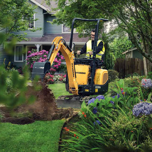 excavadora compacta hyundai hx10a trabajando en un jardín