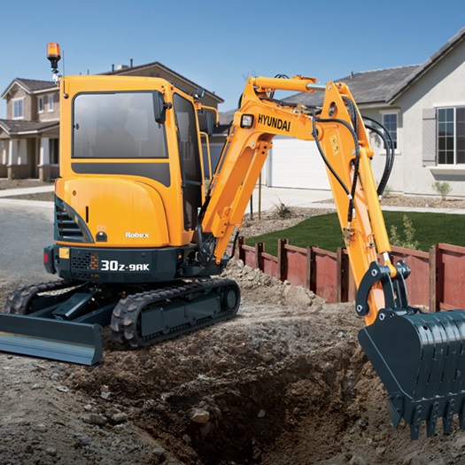 R30Z-9AK compact excavator operating near some houses