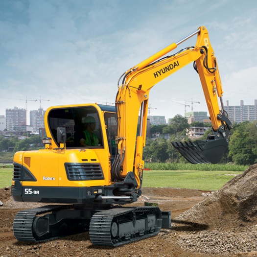 Kompaktbagger R55-9A mit einem gelben Ausleger, der Material auf einer Baustelle bewegt