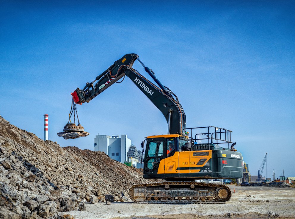 HD Hyundai HX210A L crawler excavator working on a rock pile