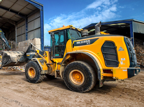 The HD Hyundai HL940A wheel loader moving material at a recycling centre