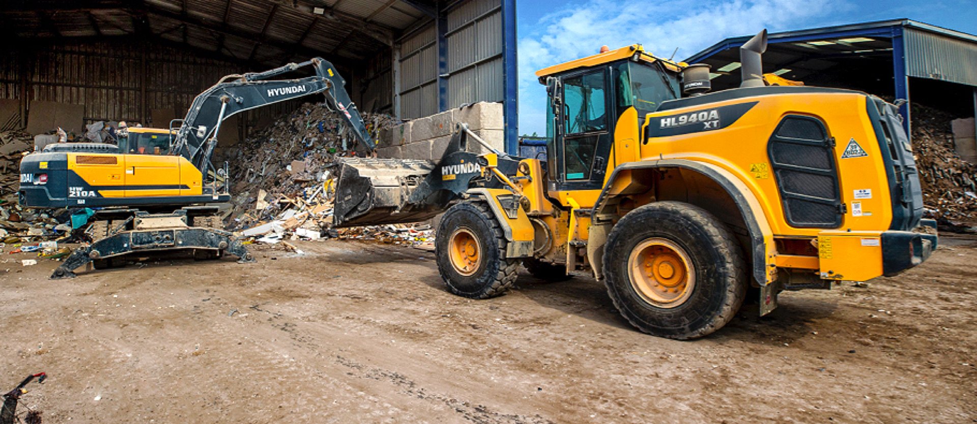 The HD Hyundai HL940A wheel loader moving material at a recycling centre