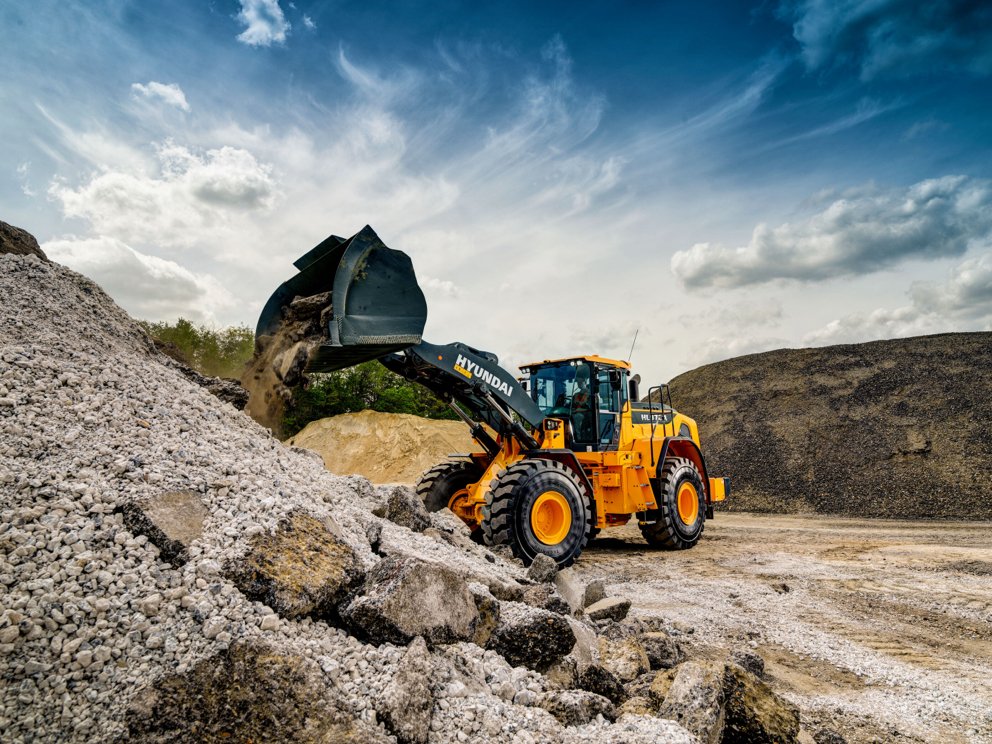 La chargeuse sur pneus HD Hyundai HL970A décharge des matériaux sur un chantier de construction