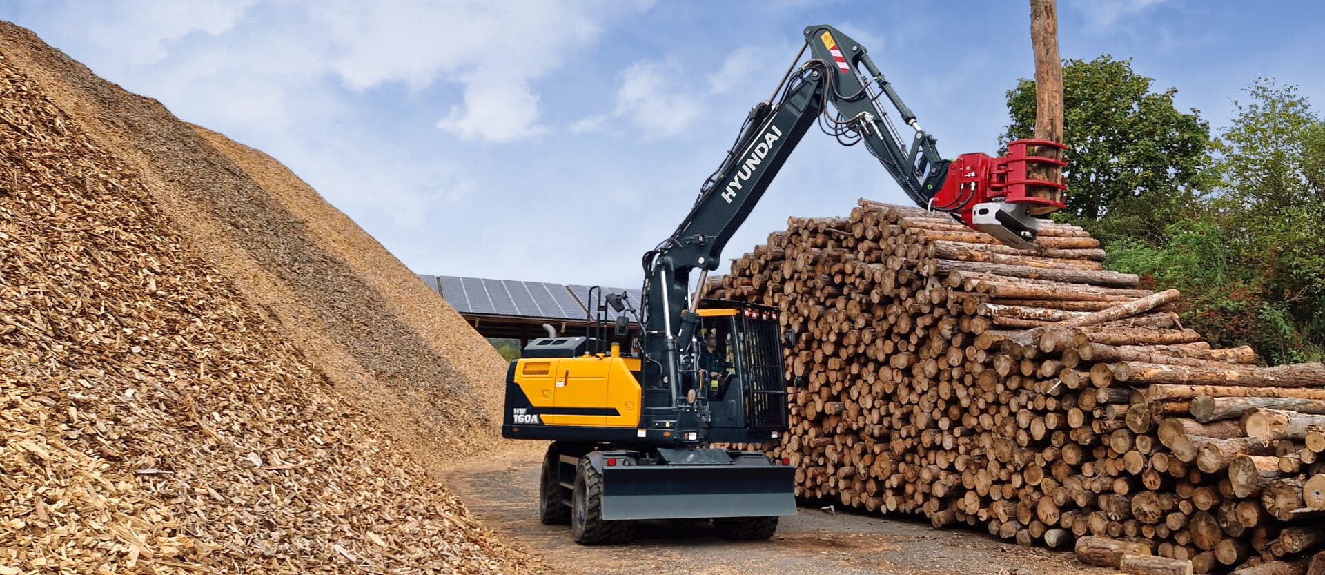 HW160A gebruikt het houtgrijperbijlage om hout te verplaatsen op een bosbouwterrein